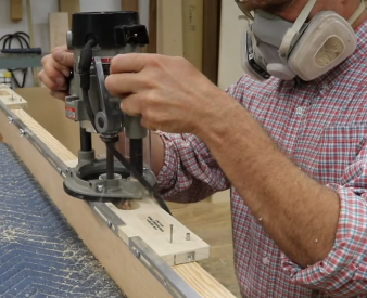 Installer using a router to install a SOSS invisible hinge on a door.