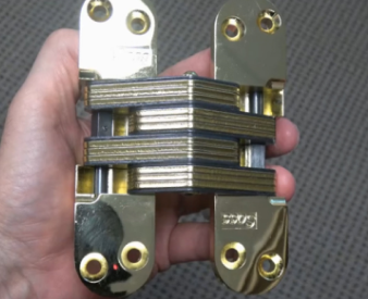 Installer holding a SOSS hinge to show how it functions.
