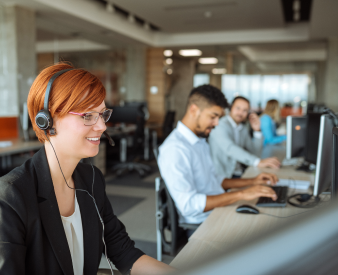 Call center with people on computers with headsets.
