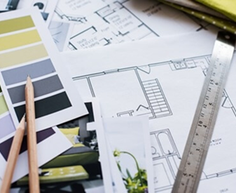 Design inspiration materials with color swatches, pencils and architectural floor plans.