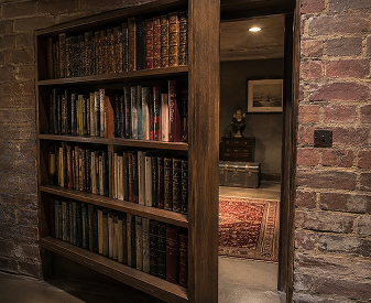 Hidden bookcase door opened to reveal a concealed room with a brick wall surround.