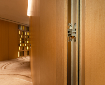 SOSS invisible hinge installed on a wood door in a modern interior hallway.