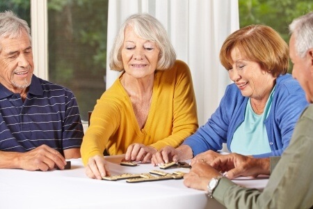 two retired couples enjoying dominos