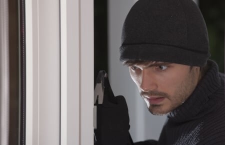 burgler with crowbar at door