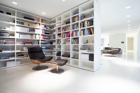 White, empty modern library with attractive chair and footstool